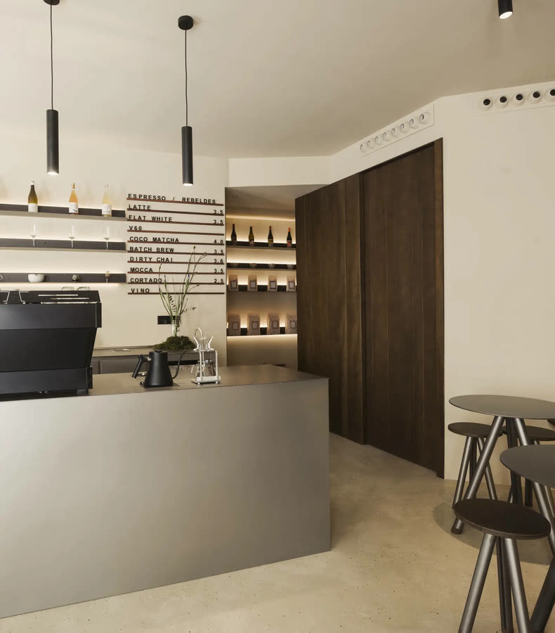 Barra de café con máquina de espresso y lámparas colgantes