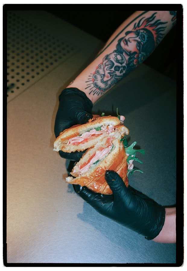 Bagel de salmón sostenido con guantes negros